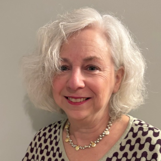 Photographic headshot of Julie Harris: a woman smiling with short white hair